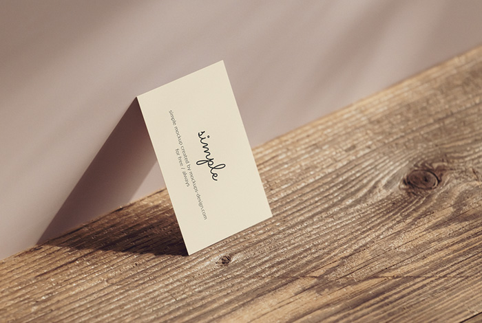 Business card lying on the wall mockup