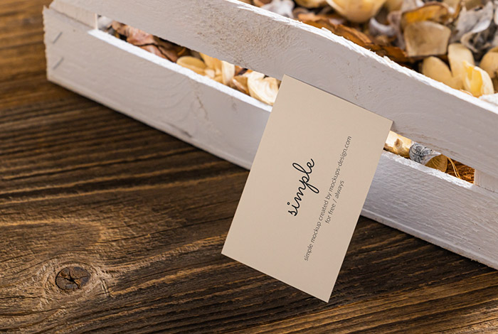 Business card next to wooden crate mockup