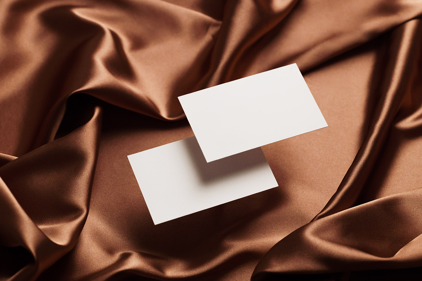Two business cards on satin background mockup